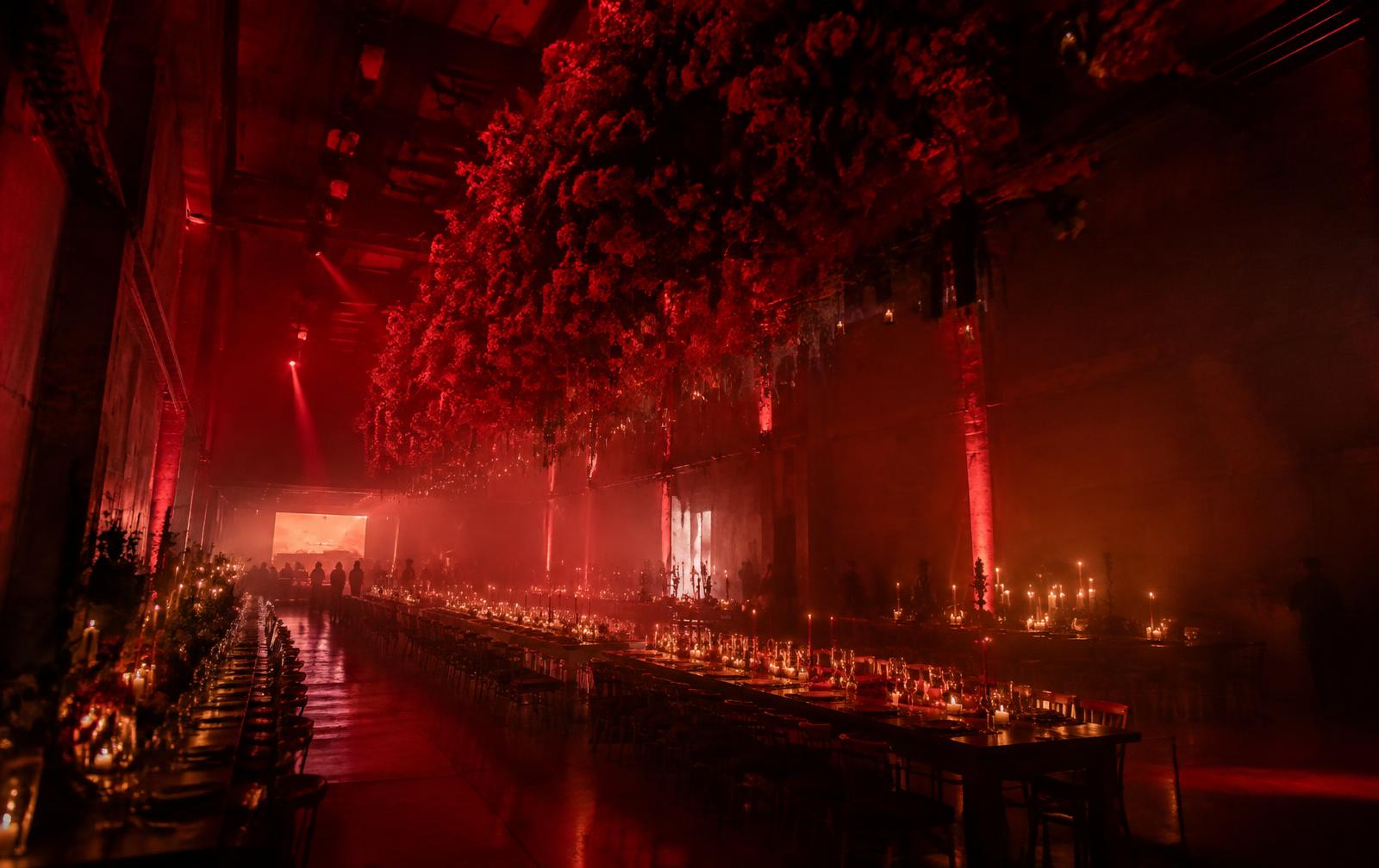 The hall transformed with a red floral cloud and candlelit tables
