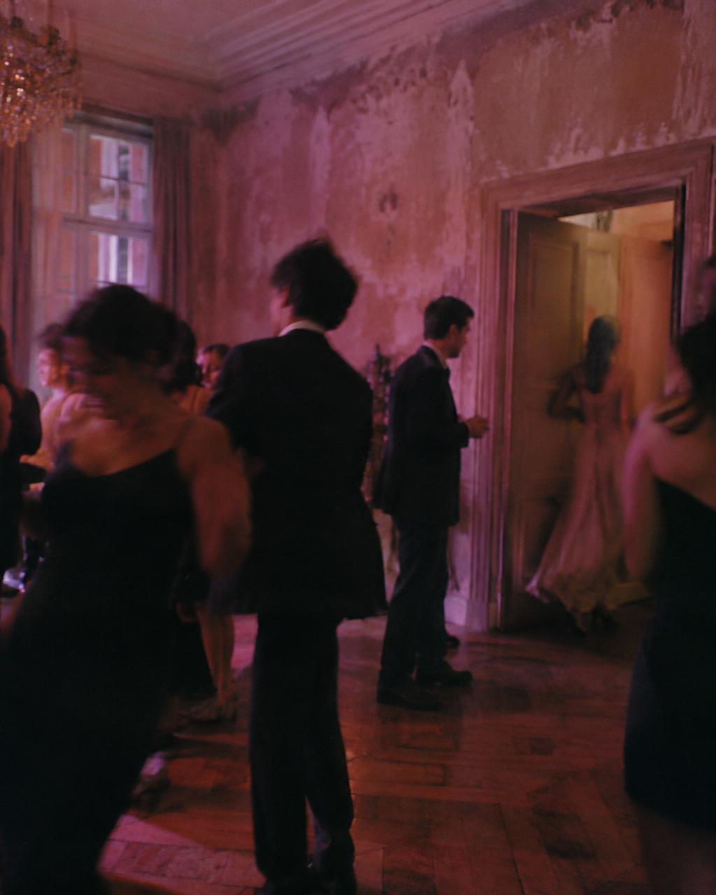 The same ballroom filled with guests, fabric and rose light